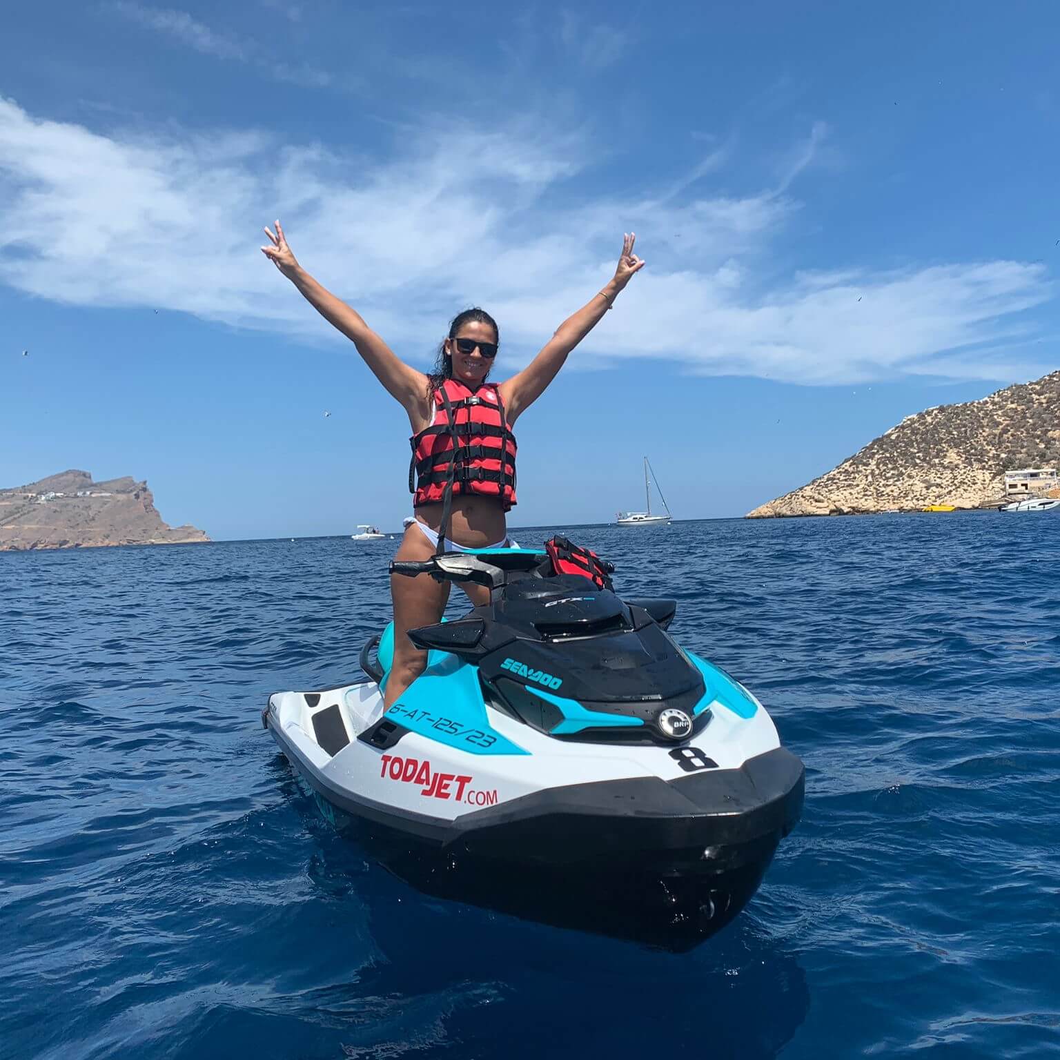 chica con brazos abiertos en moto de agua